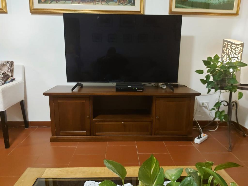 Mobile porta TV in legno noce stile arte povera con due ante e cassetto centrale.
